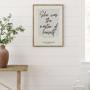 Pu&ograve; includere: Una stampa incorniciata con la citazione "She was the master of herself" in una scrittura elegante. Il testo &egrave; ambientato su uno sfondo color crema con un aspetto sottile e strutturato. La cornice &egrave; in un caldo tono di legno naturale e la stampa &egrave; esposta su un muro bianco.