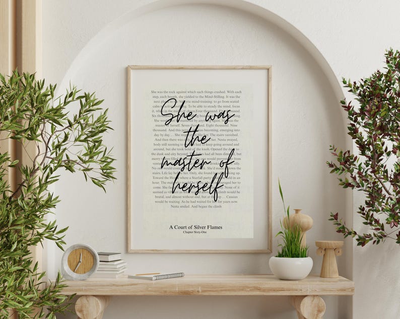 Pu&ograve; includere: Una stampa incorniciata con la citazione "She was the master of herself" in una scrittura elegante. La stampa &egrave; ambientata su uno sfondo di pagine di libro. La parte inferiore della stampa recita "A Court of Silver Flames Chapter Sixty-One".