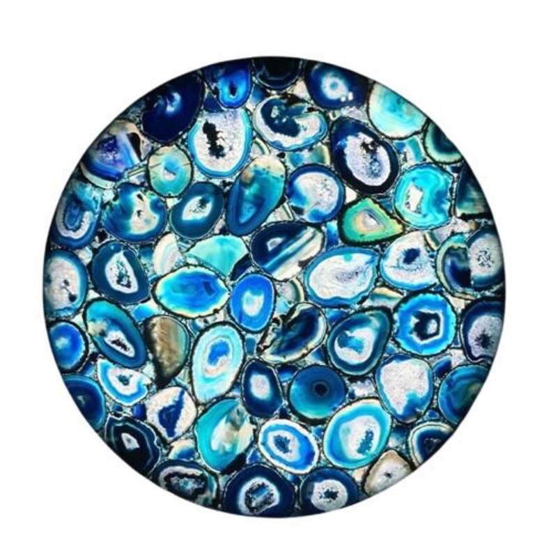 Puede incluir: Pieza decorativa circular con un mosaico de piedras de &aacute;gata azules y blancas. Las piedras muestran diferentes tonos de azul, desde el azul marino oscuro hasta el turquesa claro, con acentos blancos y grises. El dise&ntilde;o presenta un patr&oacute;n natural y org&aacute;nico.