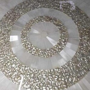 Puede incluir: Elemento decorativo circular con anillos conc&eacute;ntricos. Los anillos exteriores tienen un aspecto met&aacute;lico plateado texturizado, mientras que los anillos interiores son de material blanco liso. El dise&ntilde;o tiene un patr&oacute;n radial, creando una sensaci&oacute;n de profundidad y dimensi&oacute;n.