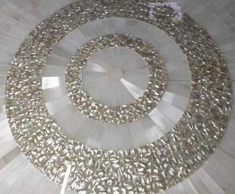 Puede incluir: Elemento decorativo circular con anillos conc&eacute;ntricos. Los anillos exteriores tienen un aspecto met&aacute;lico plateado texturizado, mientras que los anillos interiores son de material blanco liso. El dise&ntilde;o tiene un patr&oacute;n radial, creando una sensaci&oacute;n de profundidad y dimensi&oacute;n.
