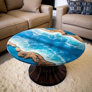 May include: Oval coffee table with a unique ocean-themed design. The tabletop features a blue epoxy resin with white wave details and brown wood accents, supported by a dark brown, pedestal base. The table sits on a white rug.