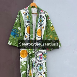 May include: A green and white patterned kimono robe with floral and geometric designs. The robe is hanging on a wooden hanger. The text "SanatextileCreations" is visible on the front of the robe.