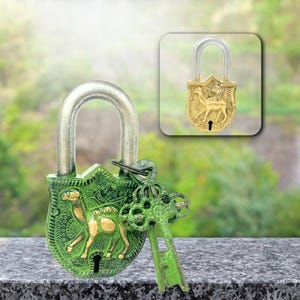 Op de afbeelding: Groen en goud decoratief hangslot met een kameelontwerp. Het hangslot heeft een zilveren beugel en wordt geleverd met twee groene sleutels. Een kleiner, goudkleurig hangslot met hetzelfde kameelontwerp is ook afgebeeld.