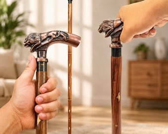May include: Three walking sticks with dark brown wooden shafts and metallic copper-coloured handles shaped like lion heads. The shafts feature small, inlaid brass-coloured accents along the length, and the handles display detailed lion carvings.