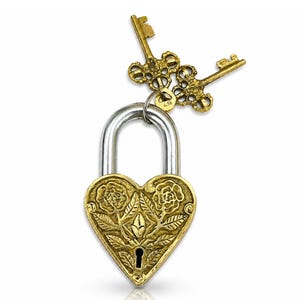 May include: A heart-shaped brass padlock with a silver shackle and two ornate brass keys. The padlock is decorated with floral designs. The keys are intricately detailed. The lock and keys are set against a white background.