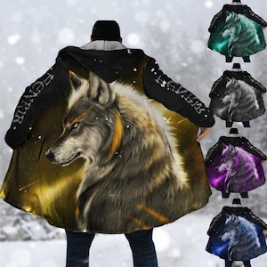 Könnte beinhalten: Ein Kapuzenmantel mit einer detaillierten Wolfsillustration in Grau-, Braun- und Goldtönen. Auf den Ärmeln steht das Wort "FENRIR". Zusätzliche Bilder zeigen den Umhang in verschiedenen Farbschemata, darunter Grün, Grau, Lila und Blau.