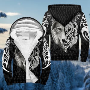 May include: Black zip-up hoodie with a wolf design. The jacket features a detailed wolf face on the front and back, with white tribal patterns and runes. The interior lining is white, and the background is a snowy forest.