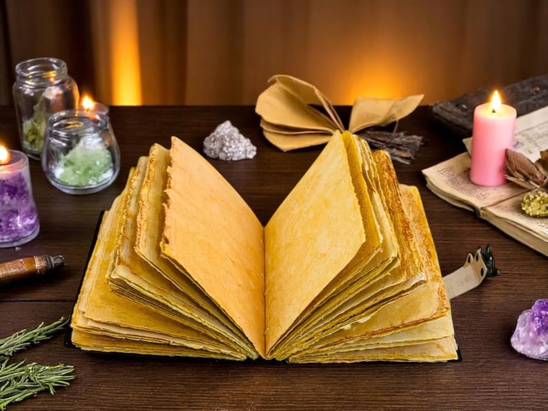 May include: An open, aged book with yellowed pages is the focal point, surrounded by candles, crystals, and jars. The scene evokes a mystical or fantasy theme, with a pink candle and other items adding to the ambiance.