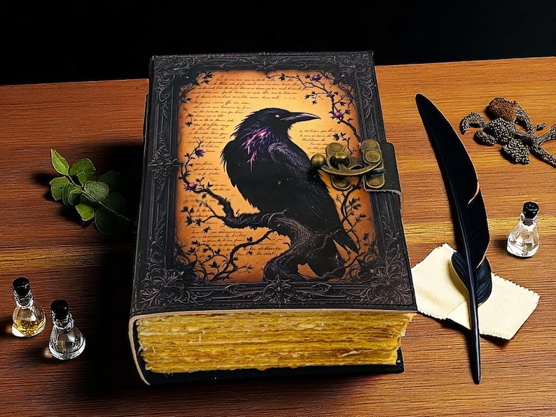 May include: A leather-bound journal with a raven illustration. The cover features a black raven perched on a branch against a parchment-like background. The journal has a metal clasp and aged, yellowed pages. A black feather quill and ink bottle are nearby.