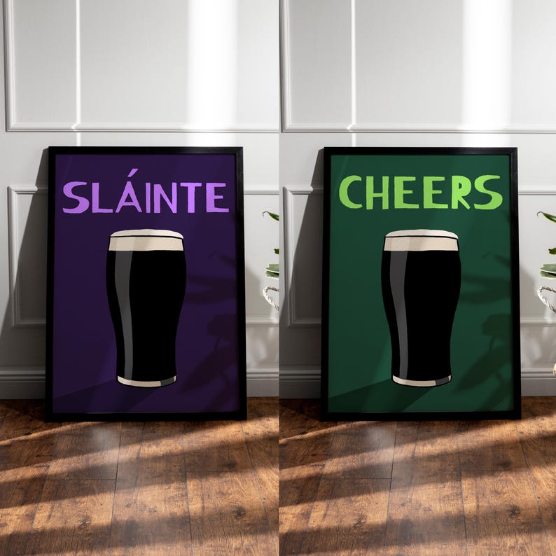May include: Two framed art prints. One features the word "SL&Aacute;INTE" in purple above a pint of stout on a purple background. The other print says "CHEERS" in green above a pint of stout on a green background.