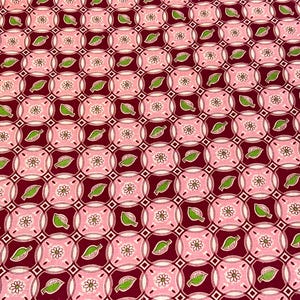 May include: A patterned fabric featuring a repeating design of pink circles with white flowers, green leaves, and small white squares on a dark red background. The fabric has a symmetrical, geometric pattern.