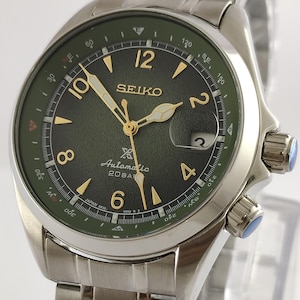 Peut inclure: Montre automatique Seiko en acier inoxydable avec un cadran vert et des aiguilles et index dorés. La montre dispose d'un guichet de date à 3 heures et d'un bracelet en acier inoxydable. La montre est étanche à 20 bars.