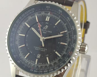 May include: A Breitling Navitimer GMT chronometer watch with a dark blue dial, silver-tone hands, and indices. The watch features a circular slide rule bezel, a date window at the six o'clock position, and a brown leather strap with a crocodile pattern.