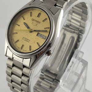Vintage Seiko 5 automatisch horloge: gouden wijzerplaat, dag-datum, onderhouden