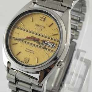 Vintage Seiko 5 automatisch horloge: gouden wijzerplaat, dag-datum, onderhouden