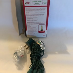 May include: A package of 20 clear mini lights with green wire. The package shows an actual size image of a light bulb. The text on the package reads "20 mini lights clear green wire".