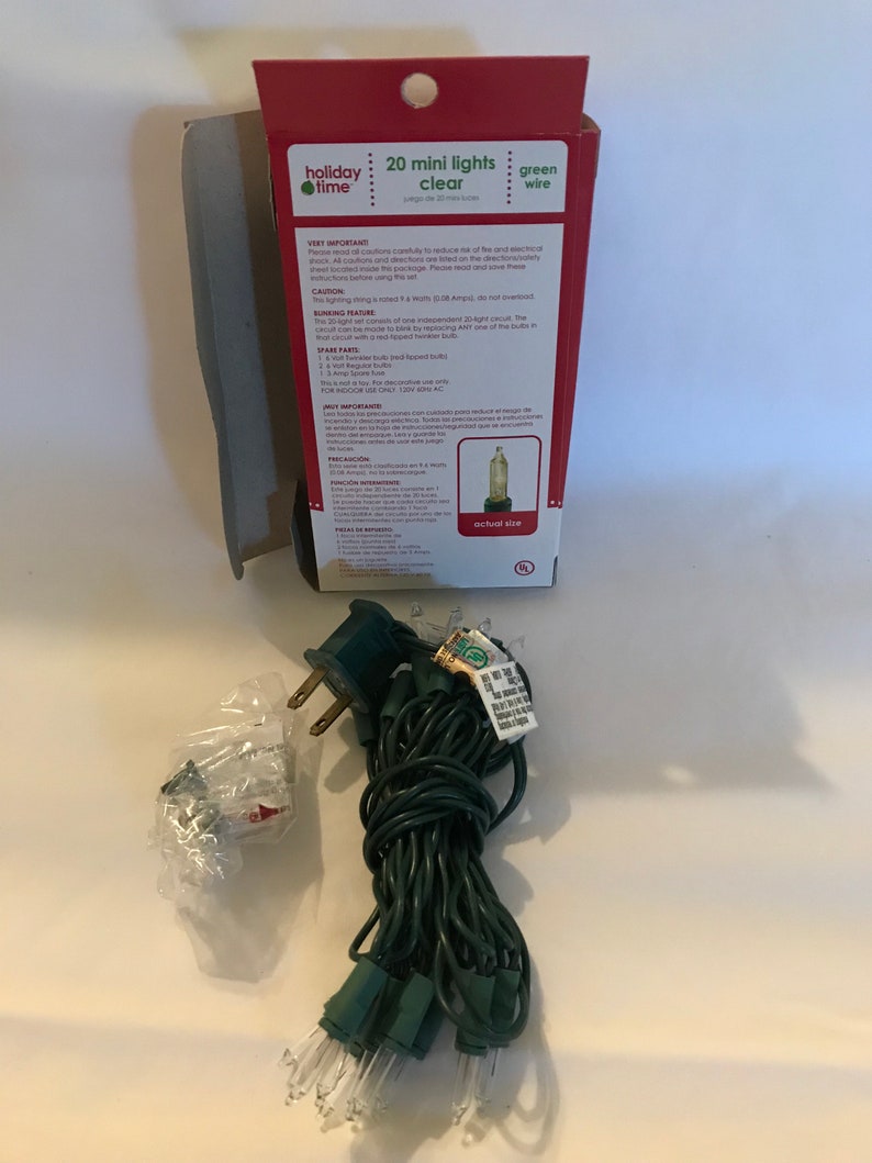 May include: A package of 20 clear mini lights with green wire. The package shows an actual size image of a light bulb. The text on the package reads "20 mini lights clear green wire".