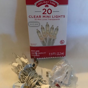 May include: A package of 20 clear mini lights with white wire. The lights are 7.5 feet long and are for indoor use. The package is red and white with the text "Holiday Time" and "20 Clear Mini Lights".