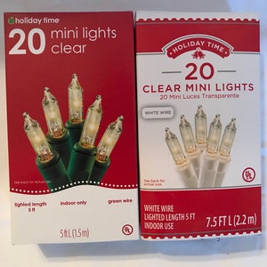 May include: Two boxes of 20 clear mini lights. The box on the left has green wire and is for indoor use only. The box on the right has white wire and is for indoor use. Both boxes have a lighted length of 5 feet.