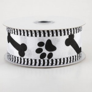 May include: A roll of white ribbon with a black dog bone and paw print pattern. The ribbon has a black and white striped border. This ribbon is perfect for crafting and gift wrapping for pet lovers.