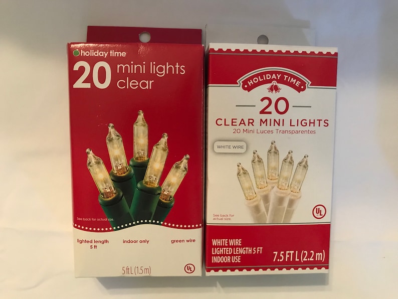 May include: Two packages of 20 clear mini lights. The package on the left has green wire and a lighted length of 5 feet. The package on the right has white wire and a lighted length of 7.5 feet. Both packages are labeled "Holiday Time".