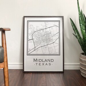 May include: A black and white map print of Midland, Texas in a brown frame. The print has the text "MIDLAND. TEXAS." at the bottom.