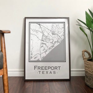 May include: A framed black and white map print of Freeport, Texas. The map is in a brown frame and the text "Freeport, Texas" is printed below the map.