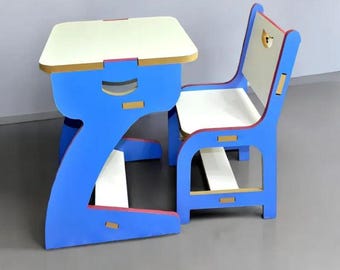 May include: A blue and white children's desk and chair set. The desk has a rectangular top with a blue base and a cutout design. The chair has a matching blue frame with a white seat and back. The set is made of wood.