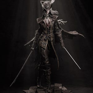 May include: A detailed statue of a character from a video game, posed with two swords. The figure wears a dark, ornate outfit with a feathered hat and long coat. The statue is set against a dark background, highlighting the intricate details.