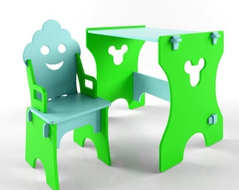 May include: A child's table and chair set in bright green and light blue. The chair back is shaped like a smiling face. The table and chair have a playful, whimsical design, perfect for a child's room or play area.