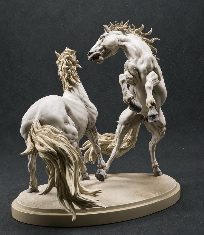 Puede incluir: Una escultura detallada en color blanco hueso que representa a dos caballos en una interacci&oacute;n din&aacute;mica. Un caballo se encabrita con la boca abierta, mientras el otro est&aacute; de espaldas con la cola al viento. Ambos sobre una base ovalada.