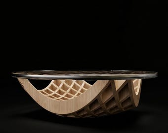 May include: A circular coffee table featuring a light-toned wooden base with a curved, lattice-style grid structure. The tabletop is a flat, circular surface with a dark, reflective finish and a thin, polished metallic edge trim.
