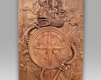 May include: A rectangular wooden wall plaque featuring a relief carving of a sailing ship positioned above a compass rose. A thick rope encircles the compass, which is marked with cardinal directions, and a large anchor sits at the bottom.