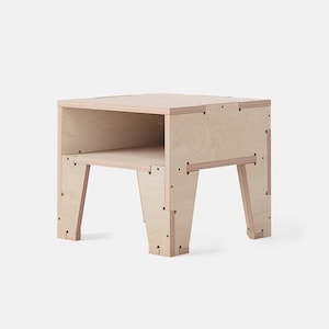 May include: A light-coloured wooden side table with a simple, modern design. The table has a rectangular top with an open shelf below and four angled legs. The table measures approximately 46 cm in height, 41 cm in width, and 41 cm in depth.