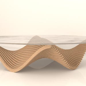 Könnte beinhalten: Moderner Couchtisch mit klarer Glasplatte und einem einzigartigen Untergestell aus geschichtetem, hellfarbigem Holz. Das Untergestell hat ein wellenförmiges Design, das dem Möbelstück eine moderne Note verleiht. Geeignet für Wohnzimmer. Maße in cm.