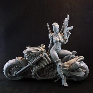 Può includere: Figurina grigia di una donna in abiti futuristici, seduta su una moto dettagliata. Tiene un fucile, con un'acconciatura mohawk e spalline a punta. La moto presenta dettagli meccanici intricati.