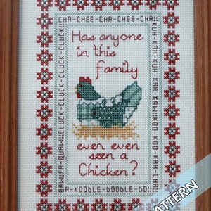 Puede incluir: Patrón de punto de cruz con un pollo de dibujos animados con el texto "Has anyone in this family ever even seen a Chicken?" en un marco blanco con un borde rojo y verde.