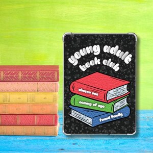 May include: A stack of colorful books next to a tablet case. The tablet case has a black background with the words "young adult book club" and three stacked books with the titles "chosen one", "coming of age", and "found family".