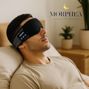 Peut inclure: Un masque de sommeil noir avec le mot "MORPHEA" et le texte "Intelligent 3D Sleep Mask" imprimé sur le côté. Le masque est porté par une personne allongée. Le masque a une sangle grise et trois boutons bleus.