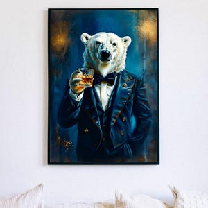 May include: Framed art print of a polar bear in a navy blue suit and bow tie, holding a glass of whiskey. The background is dark blue with gold flecks. The artwork is displayed on a white wall above a white sofa.
