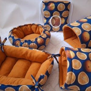 Peut inclure: Un ensemble d'accessoires pour animaux en tissu bleu à motif de tranches d'orange avec une doublure intérieure orange unie. Le lot comprend un lit rectangulaire à coins noués, un lit rond, deux cachettes en tunnel et un sac à cordon.