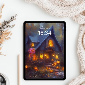 Puede incluir: Una tableta negra que muestra una ilustración digital de una casa oscura con ventanas brillantes y numerosas calabazas naranjas en el suelo. La pantalla muestra la fecha lunes 18 de junio y la hora 16:34 en texto blanco sobre fondo oscuro.