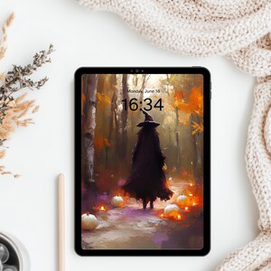 May include: A tablet displaying a digital illustration of a figure in a dark cloak and pointed hat walking through an autumn forest with glowing pumpkins. The screen shows the text Monday, June 18 and the time 16:34 in a black font.