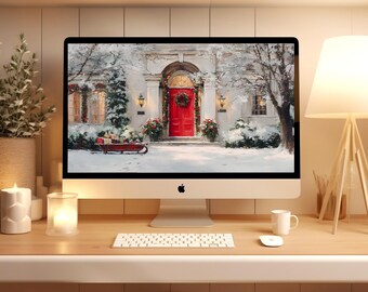 May include: A desktop computer displays a winter scene with a red door, wreath, and snow-covered landscape. The computer sits on a wooden desk with a keyboard, mouse, lamp, candles, and decorative plants. The Apple logo is visible.