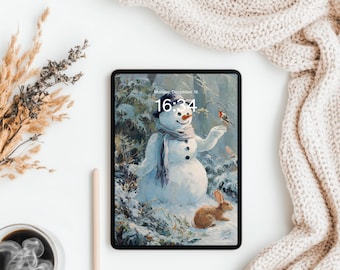 Pode incluir: Um tablet preto exibe uma cena de inverno com um boneco de neve, um pássaro e um coelho. A tela mostra a data e hora: segunda-feira, 18 de dezembro, 16:34. O tablet está em uma superfície branca, com uma xícara de café, uma caneta e um cobertor bege.