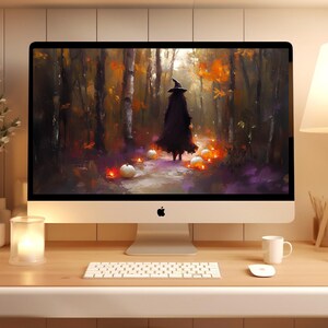 May include: A silver desktop computer with a screen displaying an oil painting of a figure in a black cloak and witch hat walking through an autumn forest with glowing pumpkins. The computer includes a white keyboard and a white computer mouse.