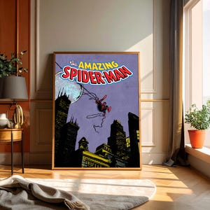 May include: Framed vintage comic book art featuring Spider-Man swinging over a city skyline. The title "The Amazing Spider-Man" is displayed in bold, colorful lettering. The artwork has a retro comic book style with a purple background.