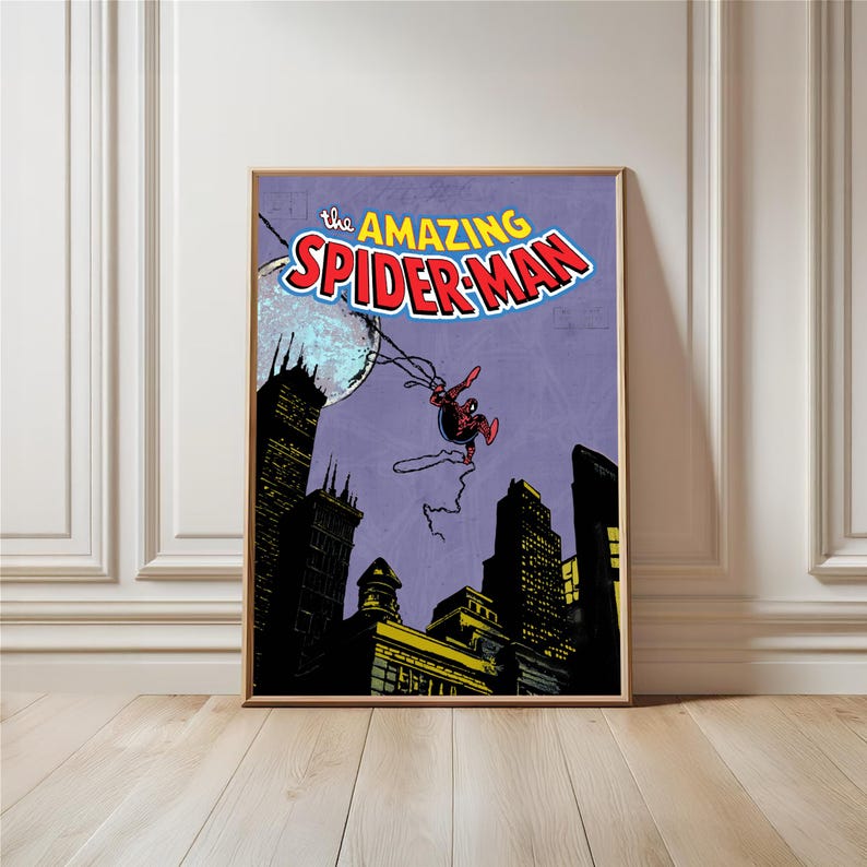 May include: A framed comic book art print featuring Spider-Man swinging through a city at night. The title "The Amazing Spider-Man" is displayed in bold, colorful lettering. The artwork has a vintage comic book style.