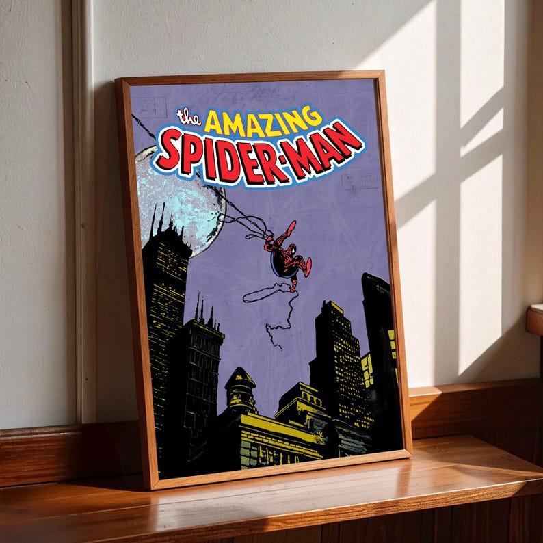 May include: A framed print featuring the Amazing Spider-Man. The artwork depicts Spider-Man swinging through a city at night, with a full moon in the background. The title "the AMAZING SPIDER-MAN" is displayed at the top.